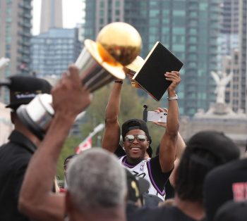 Kyle Lowry hoists the Larry O'Brien NBA Championship Trophy as the Toronto Raptors hold their victory parade in 2019