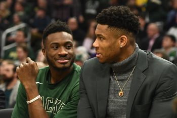 Thanasis Antetokounmpo and Giannis Antetokounmpo of the Milwaukee Bucks watch action from the bench