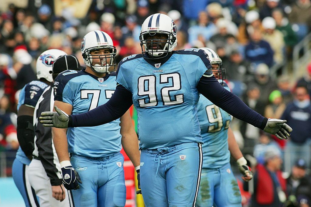 Tennessee Titans defensive tackle Albert Haynesworth (92) grimaces while a  member of the Titans staff assists him stretch out leg cramps in a football  game against the Carolina Panthers at LP Field