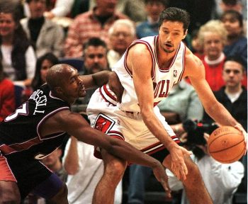 Toni Kukoc (R) of the Chicago Bulls tries to fight