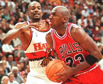 Chicago Bulls player Michael Jordan(R) pushes past