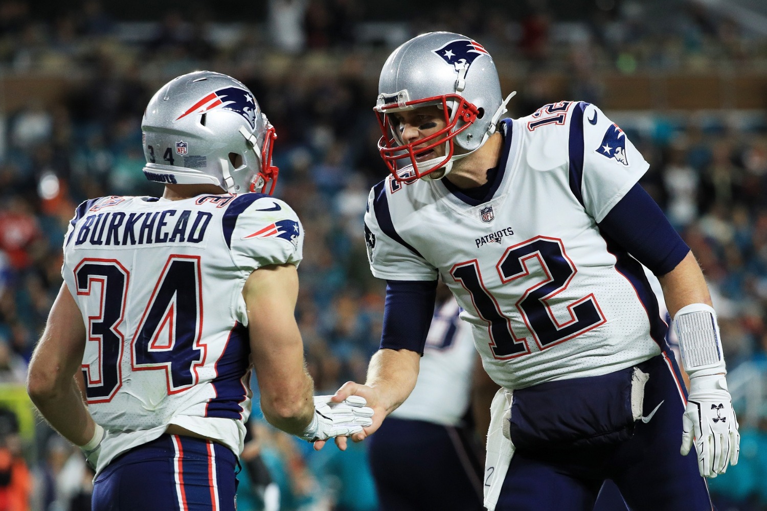 Aug 10, 2017; Foxborough, MA, USA; New England Patriots quarterback Tom  Brady (12), running back Rex Burkhead (34) and teammates warm up before the  start of the game against the Jacksonville Jagua …