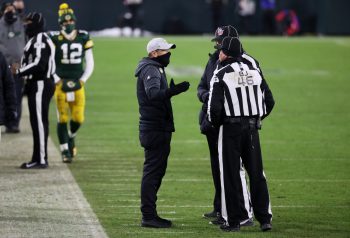 Aaron Rodgers paces the sidelines as Packers head coach Matt LaFleur speaks to the referees in the fourth quarter of the NFC championship game at Lambeau Field on Jan. 24, 2021.