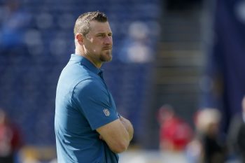 Dan Campbell stands with his arms crossed before a game.