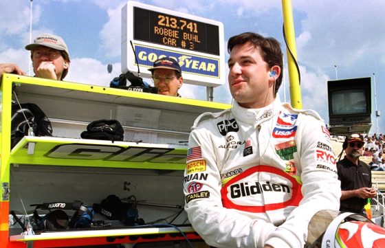 Tony Stewart watches teammate Robbie Buhl circle the track as he waits for his crew to bring out his car at the Indianapolis Motor Speedway.