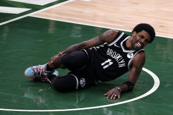 Brooklyn Nets guard Kyrie Irving goes down with an ankle injury against the Milwaukee Bucks.