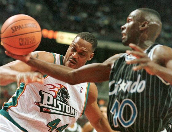 The Orlando Magic's Darrell Armstrong (R) gains control of the ball as he battles for a rebound with the Detroit Pistons' Rick Mahorn .