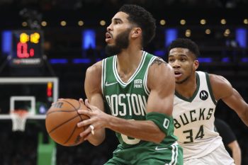 Jayson Tatum of the Boston Celtics shoots the ball while guarded by Giannis Antetokounmpo of the Milwaukee Bucks.