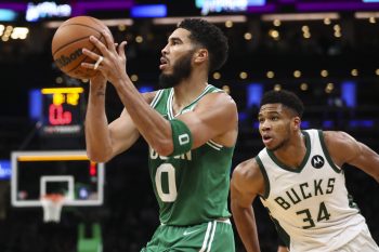 Jayson Tatum of the Boston Celtics shoots the ball while guarded by Giannis Antetokounmpo of the Milwaukee Bucks.