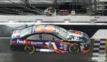 Denny Hamlin picks up the checkered flag after winning the Sprint Unlimited NASCAR Sprint Cup Series race at Daytona International Speedway on Feb. 13, 2016.