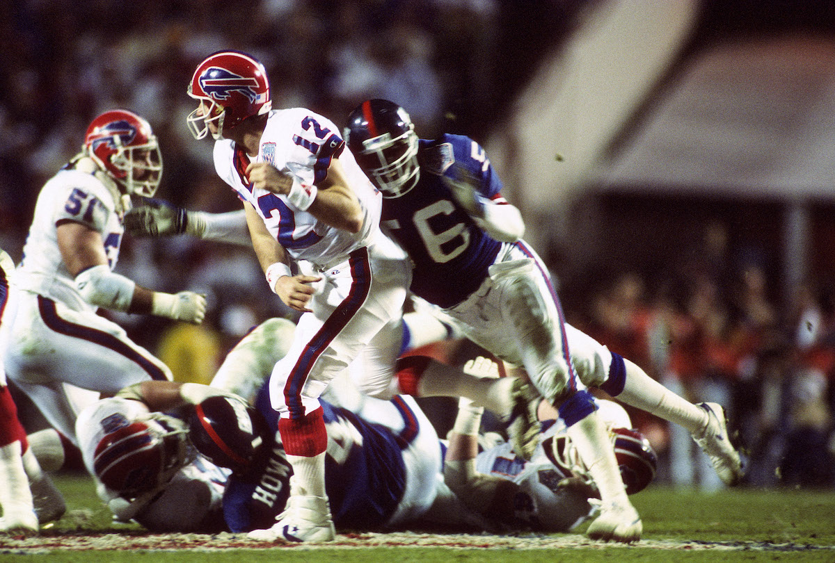 Jim Kelly of the Buffalo Bills throws under pressure from Lawrence Taylor of the New York Giants during Super Bowl XXV in 1991