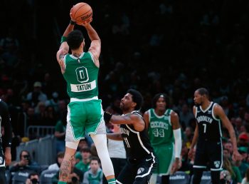 Boston Celtics forward Jayson Tatum makes a three-point basket over Brooklyn Nets guard Kyrie Irving during fourth-quarter NBA action.