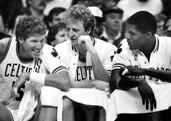 Boston Celtics stars Bill Walton, Larry, and Robert Parish talk on the bench.