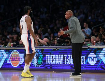 James Harden and Doc Rivers talk on the court.