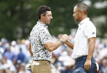 Rory McIlroy and Xander Schauffele shake hands.