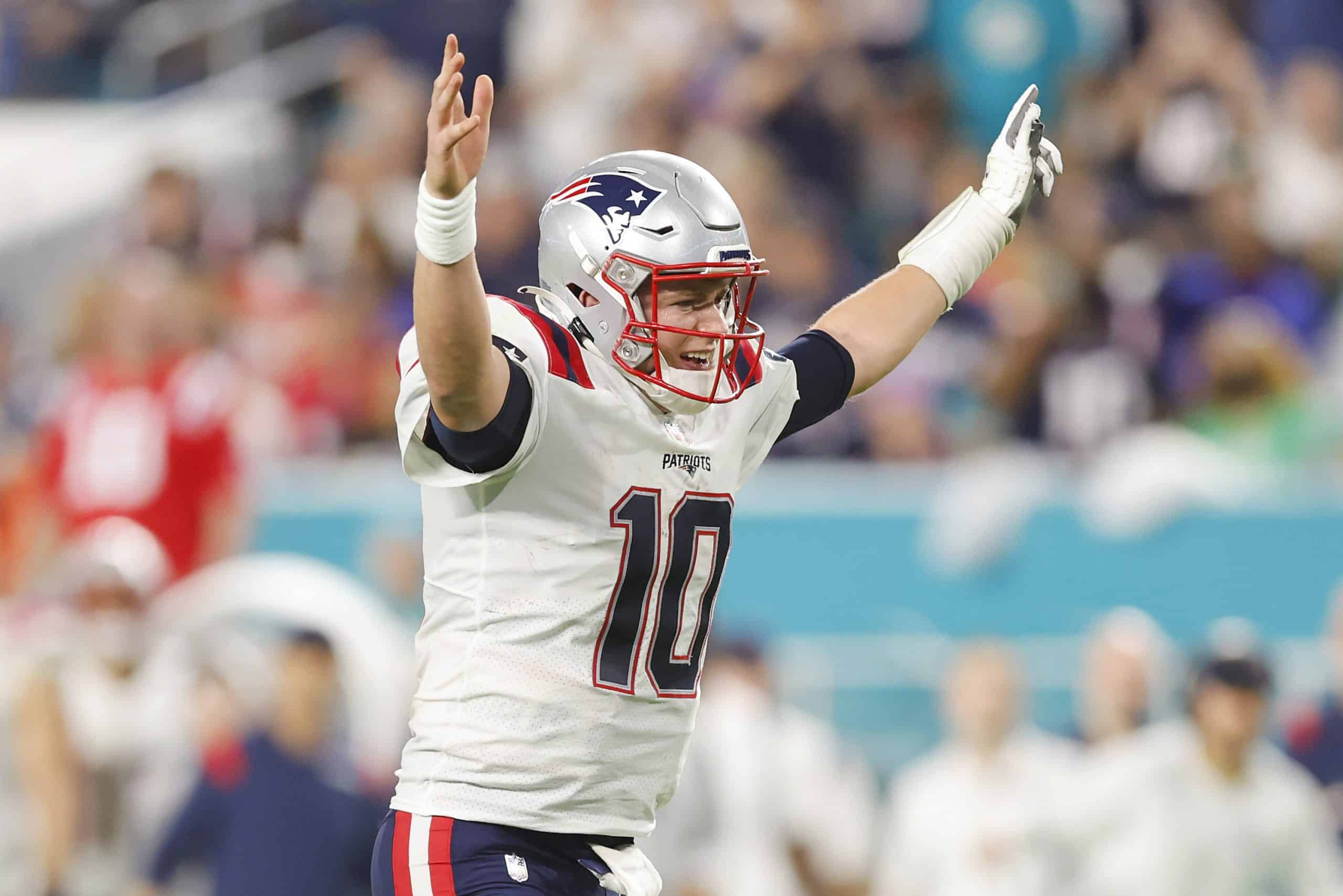 Mac Jones of the New England Patriots celebrates Damien Harris rushing for a touchdown.