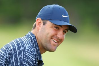 Scottie Scheffler smiles on the driving range.