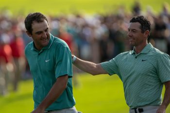 Rory McIlroy pats Scottie Scheffler on the back.