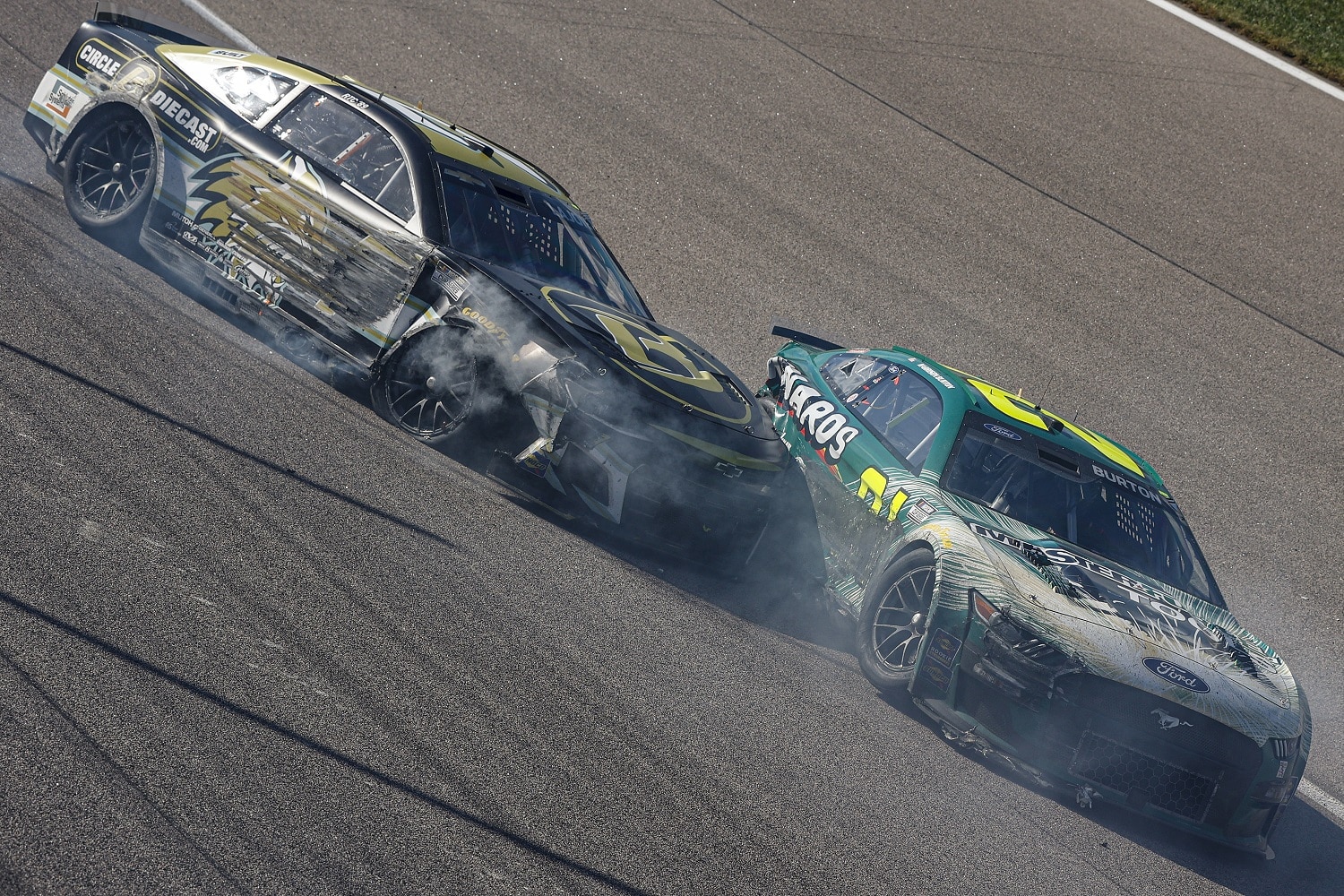 Corey LaJoie, driver of the No, 7 Chevrolet, and Harrison Burton, driver of the No. 21 Ford, spin after an on-track incident during the NASCAR Cup Series Hollywood Casino 400 at Kansas Speedway on Sept. 11, 2022. | Meg Oliphant/Getty Images