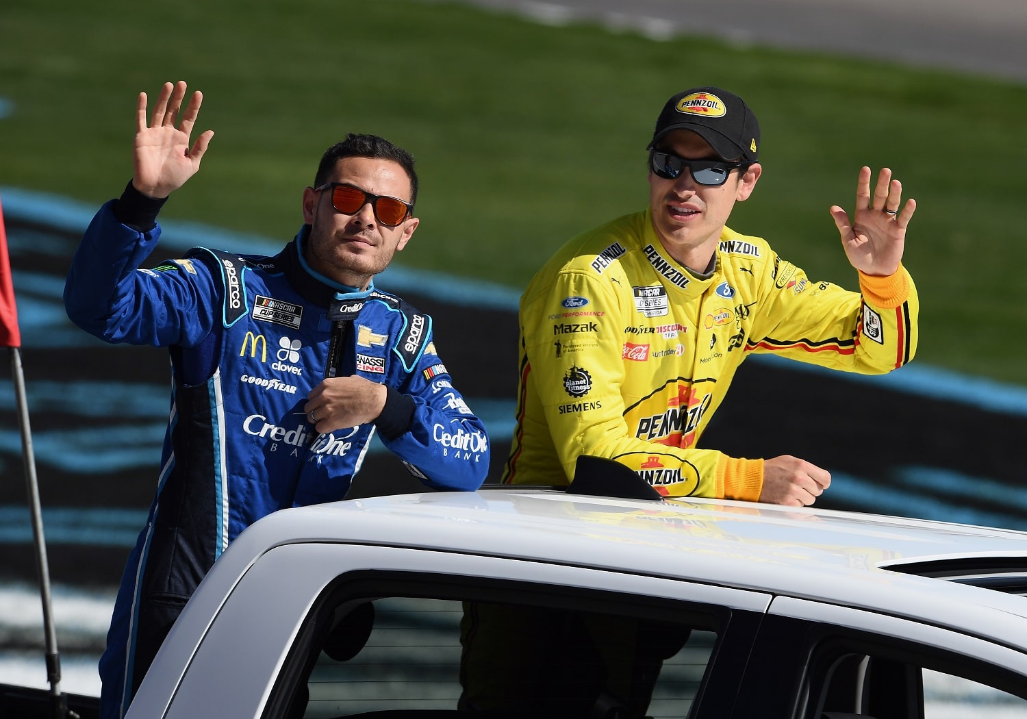 NASCAR Cup Series drivers Kyle Larson  and Joey Logano wave to the fans during a parade lap before the Pennzoil 400 on Feb. 23, 2020, at Las Vegas Motor Speedway. | John Cordes/Icon Sportswire via Getty Images