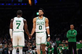 Jayson Tatum of the Boston Celtics low-fives Jaylen Brown as he enters the court.