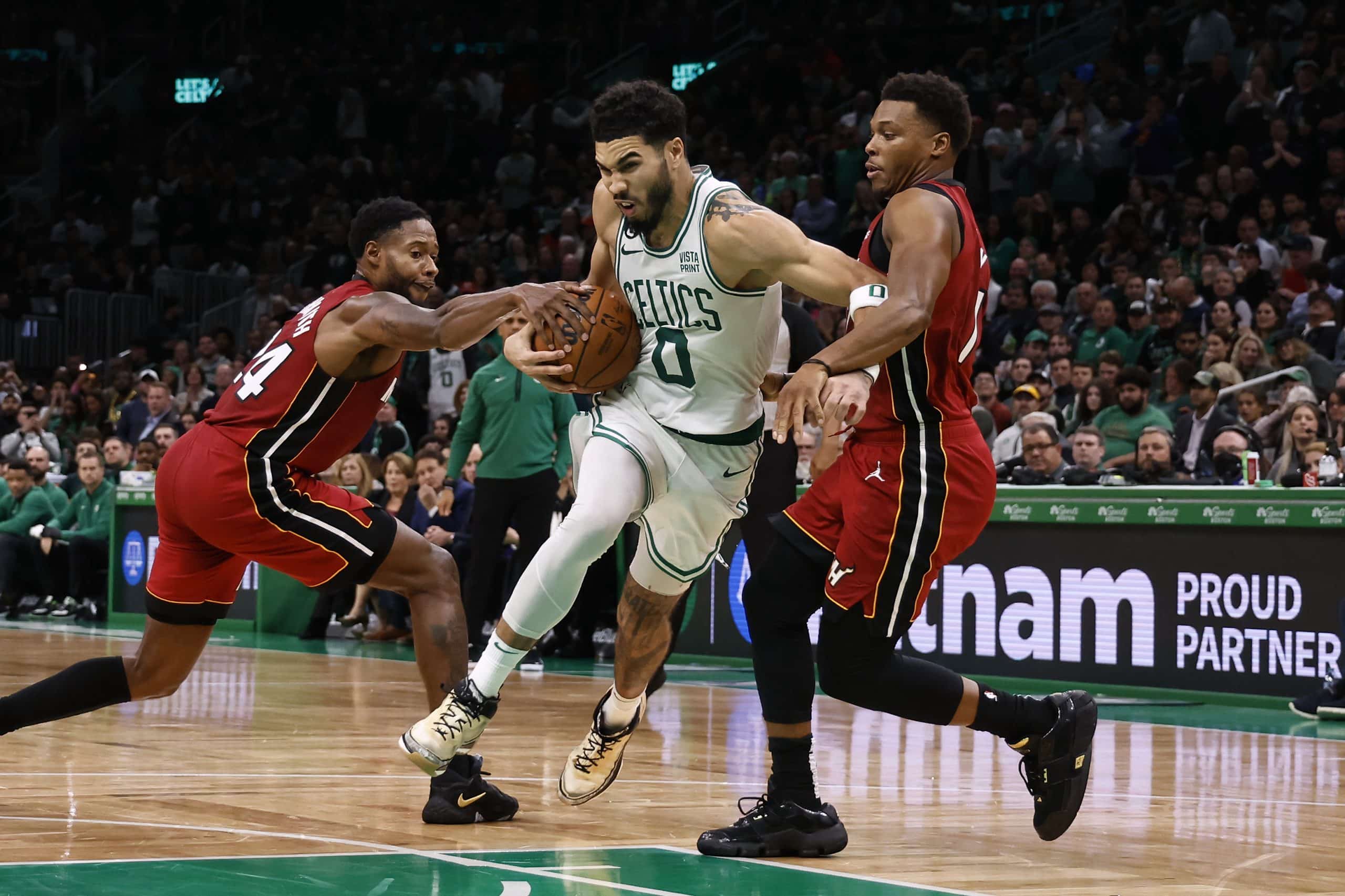 Haywood Highsmith of the Miami Heat and Kyle Lowry try to stop Jayson Tatum of the Boston Celtics.