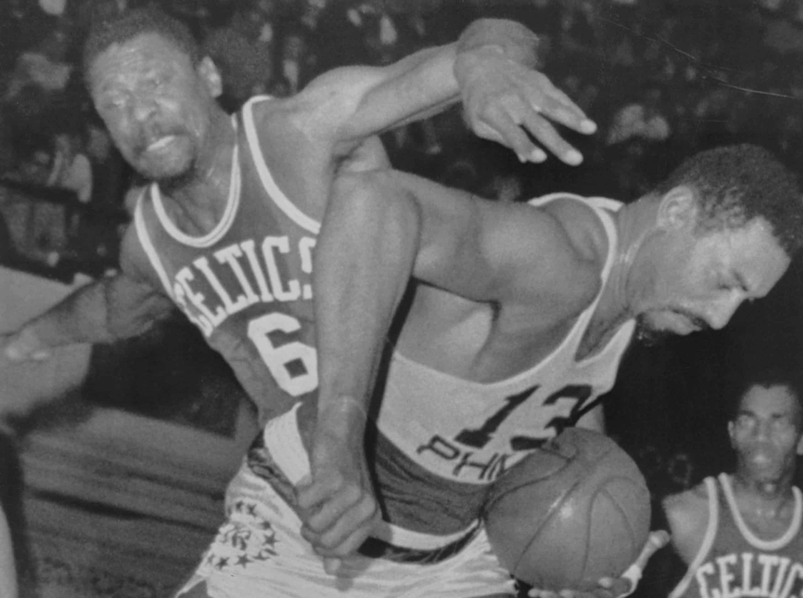76ers center Wilt Chamberlain (13) fights Boston Celtics star Bill Russell for a rebound.