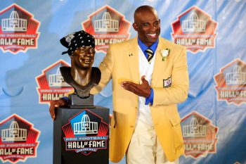 Former NFL cornerback Deion Sanders poses with his bust at the Enshrinement Ceremony for the Pro Football Hall of Fame in 2011