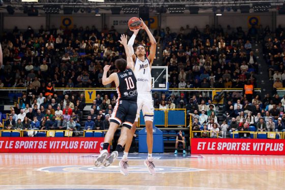 Victor Wembanyama takes a jump shot over a defender.