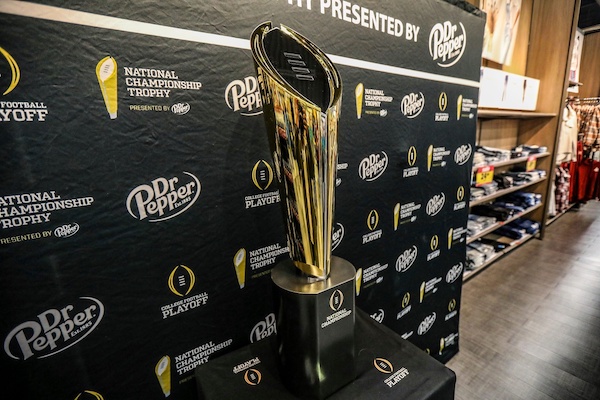 Fans stop to take photos with the College Football National Championship trophy