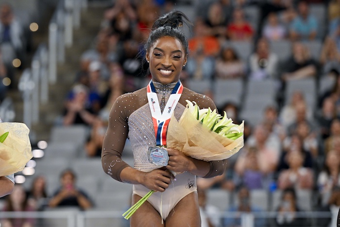 Simone Biles of World Champions Centre poses for a photo with her gold medal.