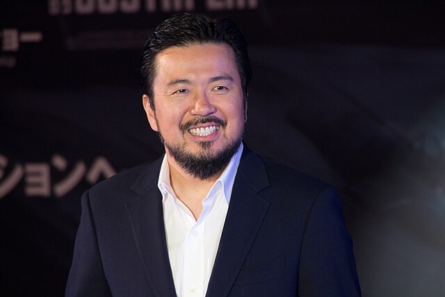 Justin Lin smiles on the red carpet.