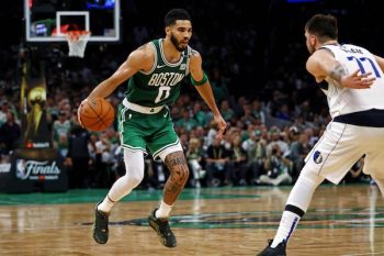 Boston Celtics forward Jayson Tatum (0) handles the ball against Dallas Mavericks guard Luka Doncic (77) .