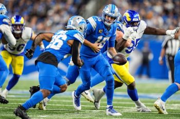 Detroit Lions quarterback Jared Goff (16) hands the ball to running back Jahmyr Gibbs (26).